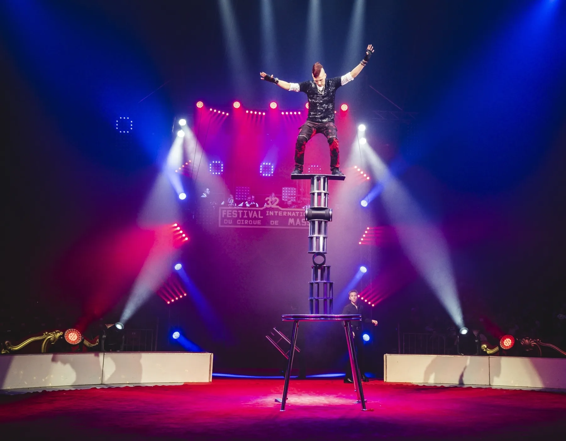 Balance-Pyramide unter Scheinwerferfächern in der Manege